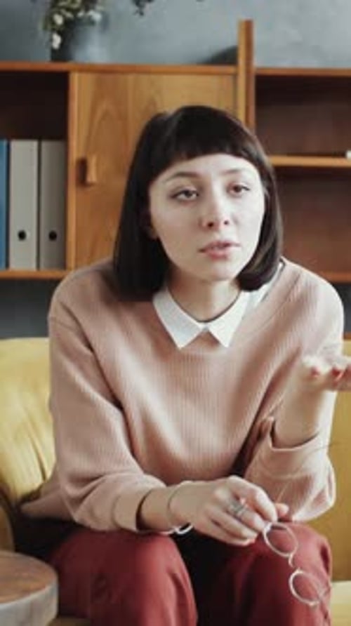 Distraught Woman Holding Glasses Indoors
