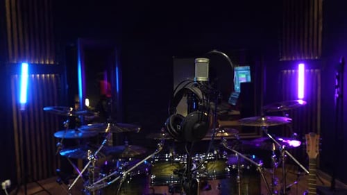 Recording studio setup with drum kit, microphone and headphones