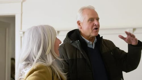 Senior Couple Talking Indoors About Real Estate