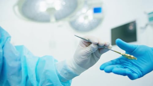 Surgeons Exchange Instrument During Operation in Hospital