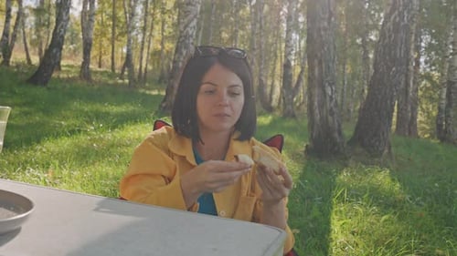 Woman Enjoys Picnic with Dog in Forest