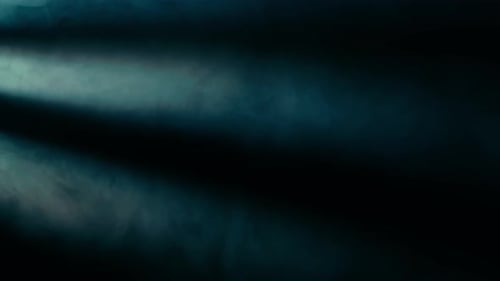 Fog and Haze Effect on a Black Background Illuminated By Spotlight Beams and Blue Neon Light