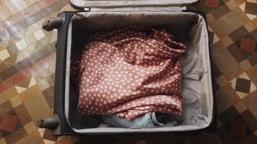 Packing Clothing into Suitcase for Vacation Preparation