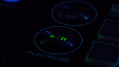 Illuminated Play Button on Black DJ Soundboard