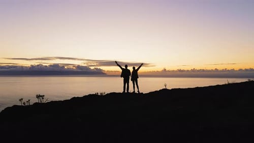 Couple Team Silhouette Two Tourists Climbed to the Top of Mountain and Raised Hands Up During Sunset