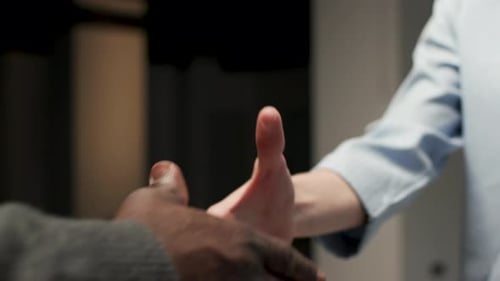 Close-up of two people shaking hands in office