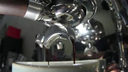 Close Up Of Espresso Spout Extracting Rich Coffee Into A Cup