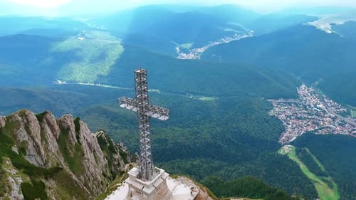 Large cross monument towering over the spectacular rocky landscape.
