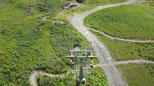 A drone follows a cable car going up the mountain in the Swiss alps, Obwalden, top aerial view
