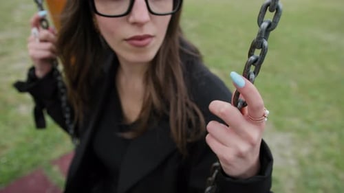 Woman Swinging in Black Jacket and Glasses