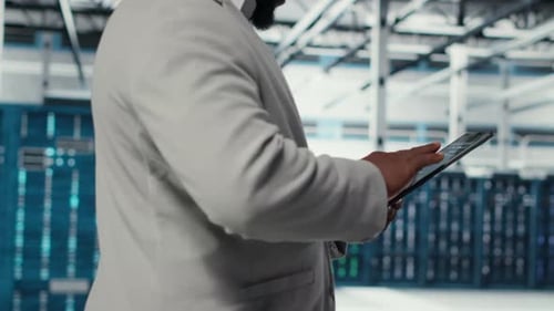 Programmer in Data Center Using Tablet to Manage Software Updates