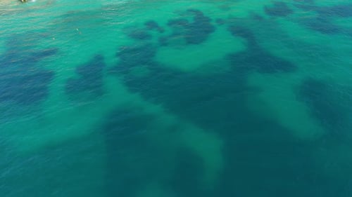 Turquoise ocean waters create a serene and calm surface with gentle color variations