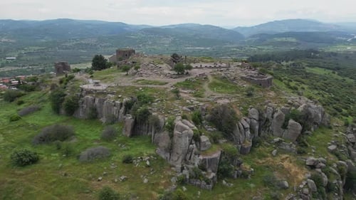 Drohnenblick auf die Ruinen auf dem Hügel von Assos, umgeben von Klippen und grünem Tal
