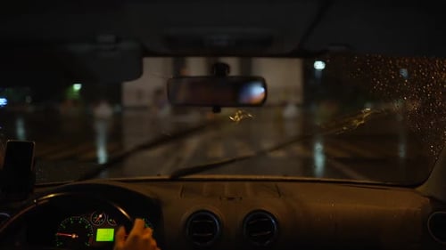 Man Driving Through a Heavy Rain Storm in a Dark Rainy City Night Lights and Rain Through the