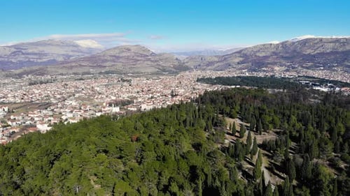 Zumbido vuela hacia atrás sobre las colinas de Podgorica cubiertas de pinos y bosques de cipreses en