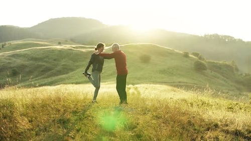 Senior Couple Sunrise Stretch on Meadow