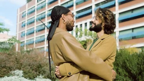Happy Gay Couple Talking While Embracing in the City