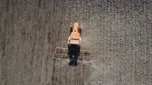 Aerial Drone Shot of Farmer in Tractor Plowing and Cultivating Agricultural Land at Field