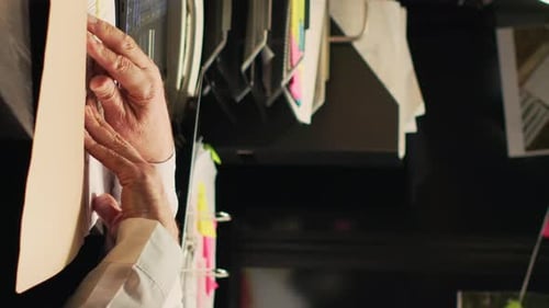 Hands Reviewing Paperwork at Cluttered Desk