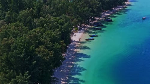 Aerial zoom-in shot of a pristine beach on Koh Kradan, Thailand, showcasing turquoise waters, soft w
