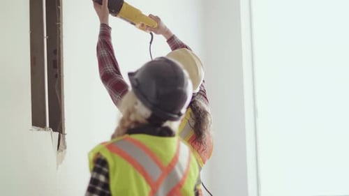 Mature contractor cuts partition wall on modern office redevelopment project in Canada