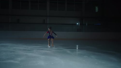 Girl Performing Figure Skating Spin on Ice Rink
