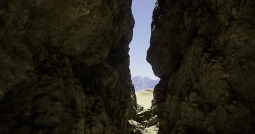 Rugged Rock Formations Lead to a Serene Sand Dune Landscape in Daytime