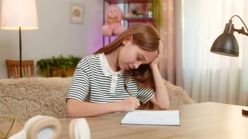 Child Girl Kid Doing School Homework at Table Happily Solving Problem Excited Expression at Home
