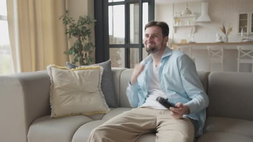 Excited Man Plays Video Game on Couch