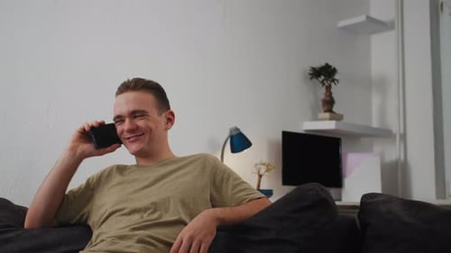 Young Adult Chatting on Smartphone at Home