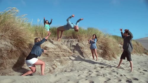 Super of Guy Doing Backflip at Beach with Friends,