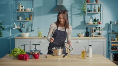 Woman Cooking and Tasting Food in Bright Kitchen