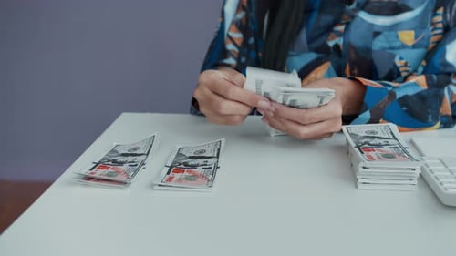 Unrecognizable Financial Manager Calculating and Counting Banknotes