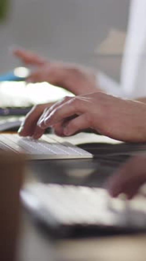 Hands Typing on Computer Keyboards in an Office