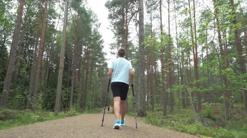 Active Woman Doing Nordic Walking in a Park