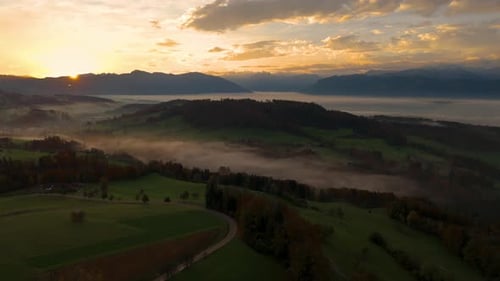 drone flight in the morning hour in autumn. The fog is down in the valley and is illuminated by the