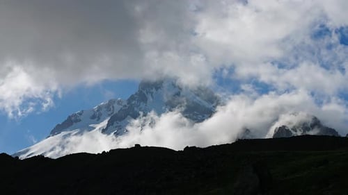Timelapse of Kazbegi Mountain in Caucasus Mountain Ridge Snowcapped Peaks with Clouds Moving Around