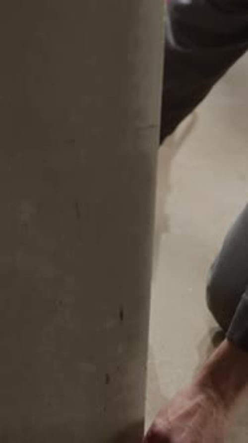 Construction Worker Measuring with Tape at Unfinished Construction Site