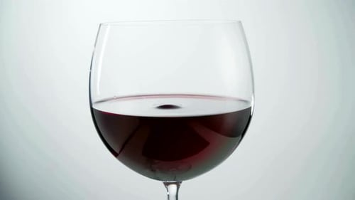 Red Wine Drop Creates Gentle Ripples in Glass