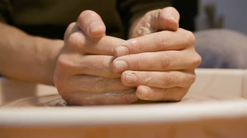 Processus de sculpture d'un artisan masculin sur la roue à poterie ronde, gros plan isolé. Dextérité artisanale