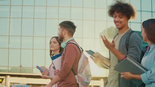 A Group of Students Talking Walking With Books at Background of College