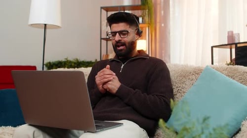 Professional Man Video Conferencing on Laptop at Home