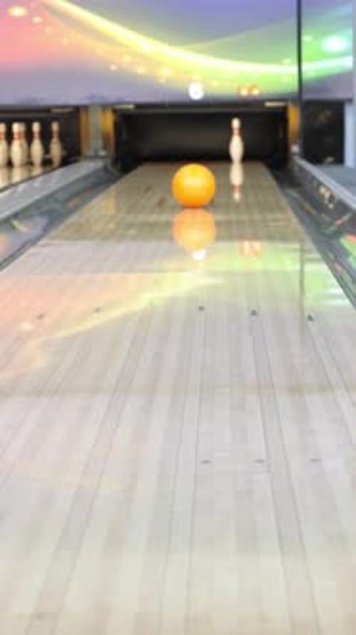 Bowling Alley Lane with Polished Wooden Surface Vibrant Lighting Effects and a Bright Orange Bowling