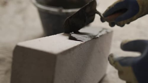 Bricklayer Applies Adhesive Glue on Autoclaved Aerated Concrete Blocks with Notched Trowel and