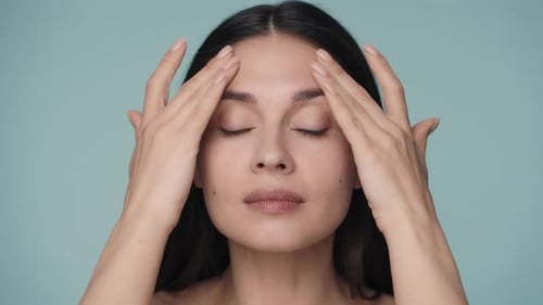 A Woman Runs Her Well Groomed Hands Over Her Face From Her Forehead to Her Temples A Young Woman