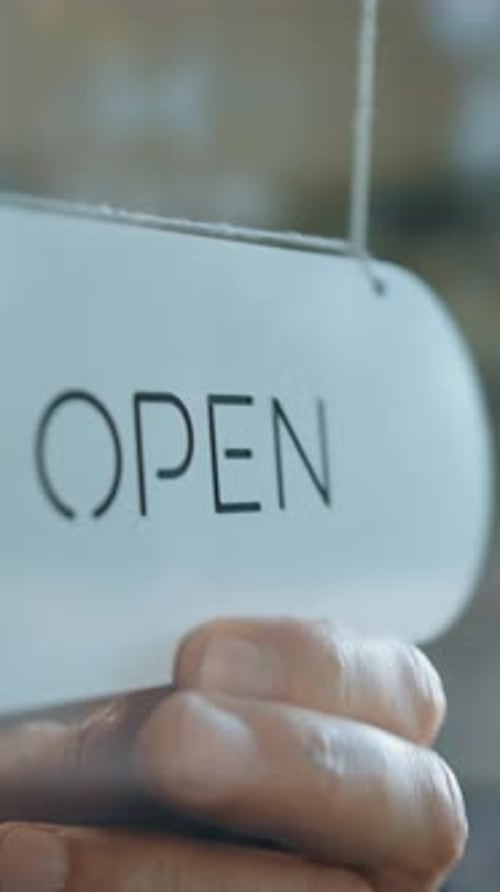 Vertical of Crop Person Turning the Plate Over From Closed to Open on Drug Store Door