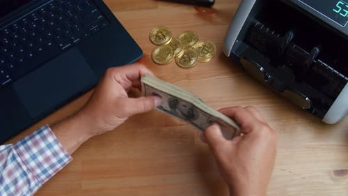 Close Up Of Hands Using Money Counting Machine With US Dollar Bills