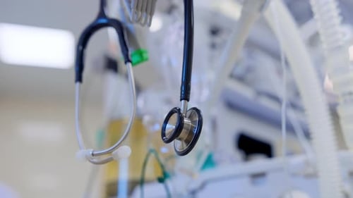 Stethoscope hanging on the equipment in modern surgical room. Low angle view. Blurred backdrop.