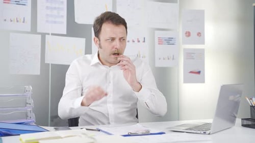 Worried Man Looking at Laptop in Bright Office