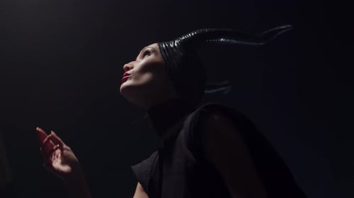 Vue du bas : une méchante sorcière méchante d'un conte de fées avec des cornes lève les yeux et essaie